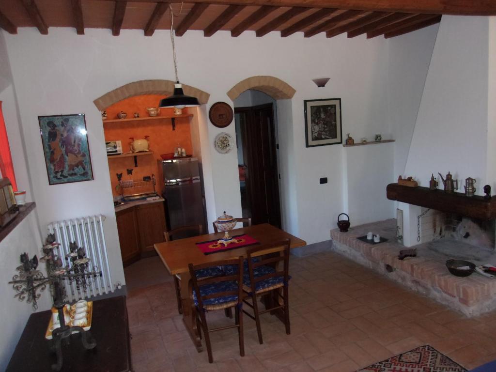 蒙特里久尼Podere Sammonti的厨房以及带桌子和壁炉的用餐室。