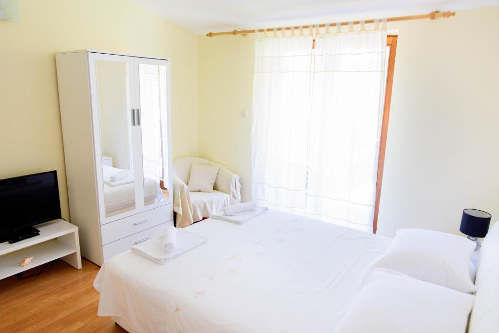 珀德垂那Apartment ANA Podstrana的卧室配有白色的床和镜子