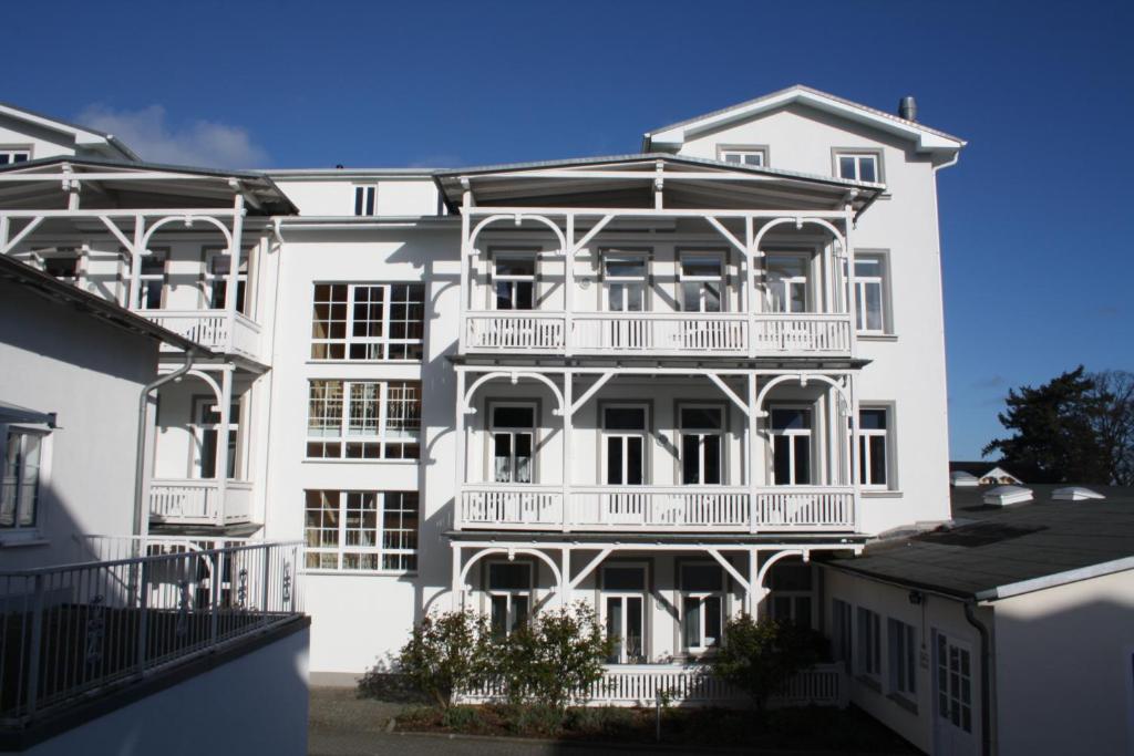 奥斯特巴德·哥伦Ferienwohnung im Ostseebad Göhren in Strandnähe, Kurhaus Nordstrand,Nähe Binz und Sellin的白色的建筑,旁边设有阳台