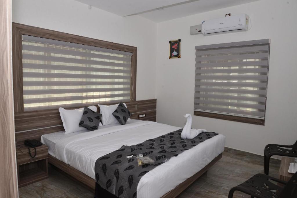 维拉杰佩特Suroor Tourist Home的一间卧室配有一张带黑白枕头的床
