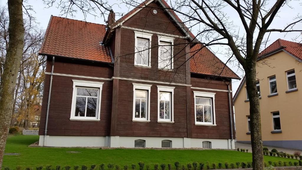 索尔陶Ferienwohnung Parkblick的一间棕色的大房子,拥有白色的窗户和树