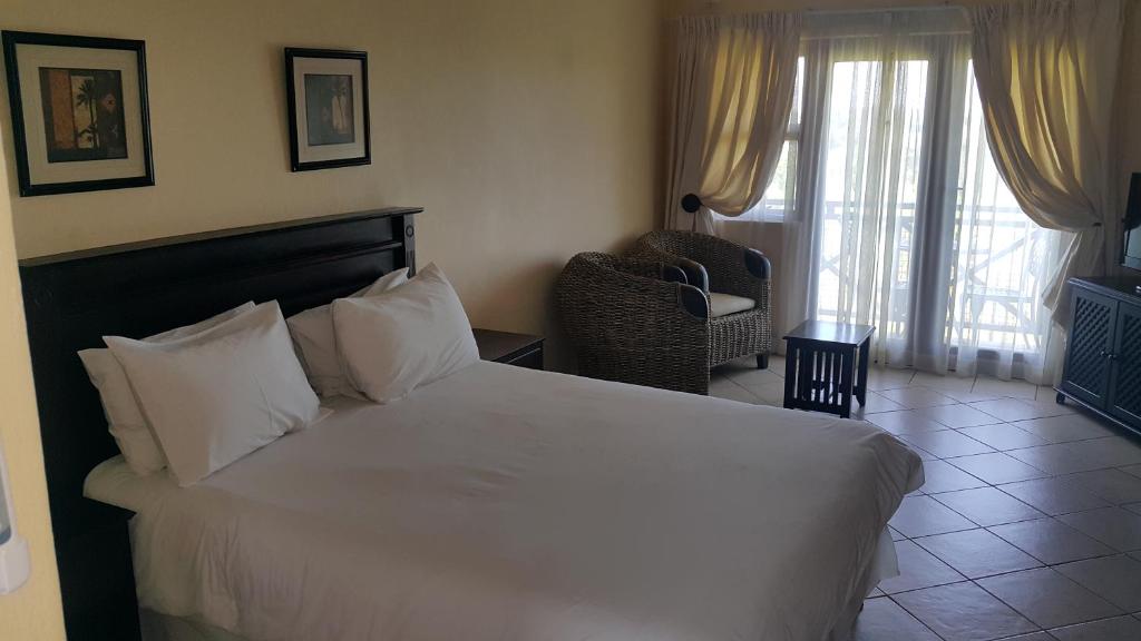 爱德华港Ocean View Villas C10的卧室配有白色的床、椅子和窗户