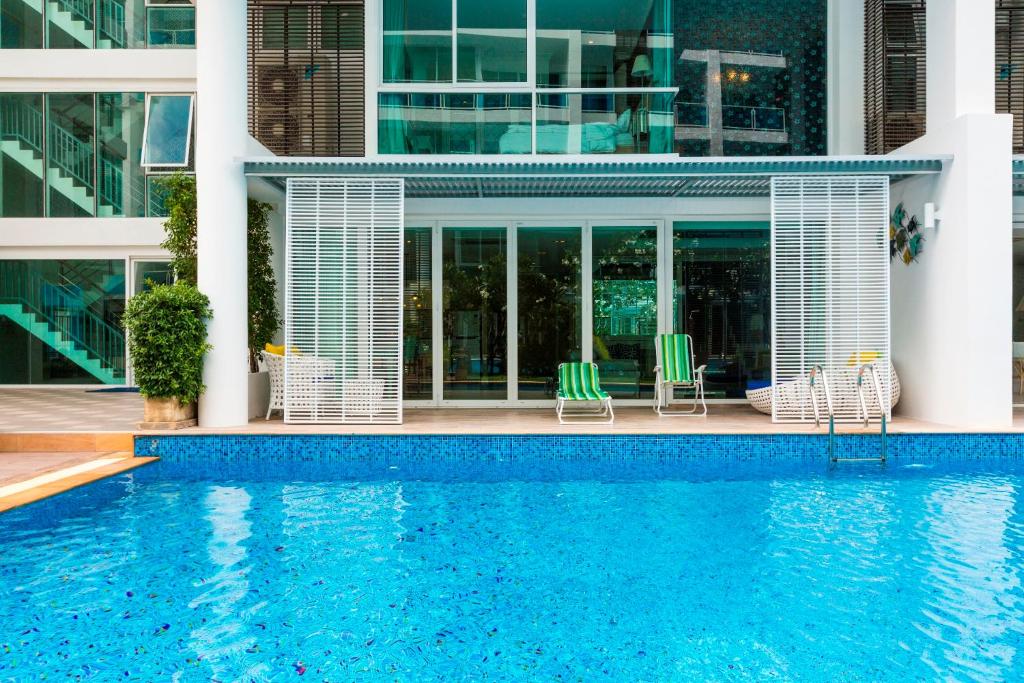 华欣3 bedrooms My resort huahin with free waterpark的大楼前带游泳池的房子