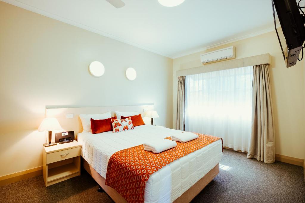 纳拉布赖Club Motor Inn的一间卧室设有一张大床和一个窗户。
