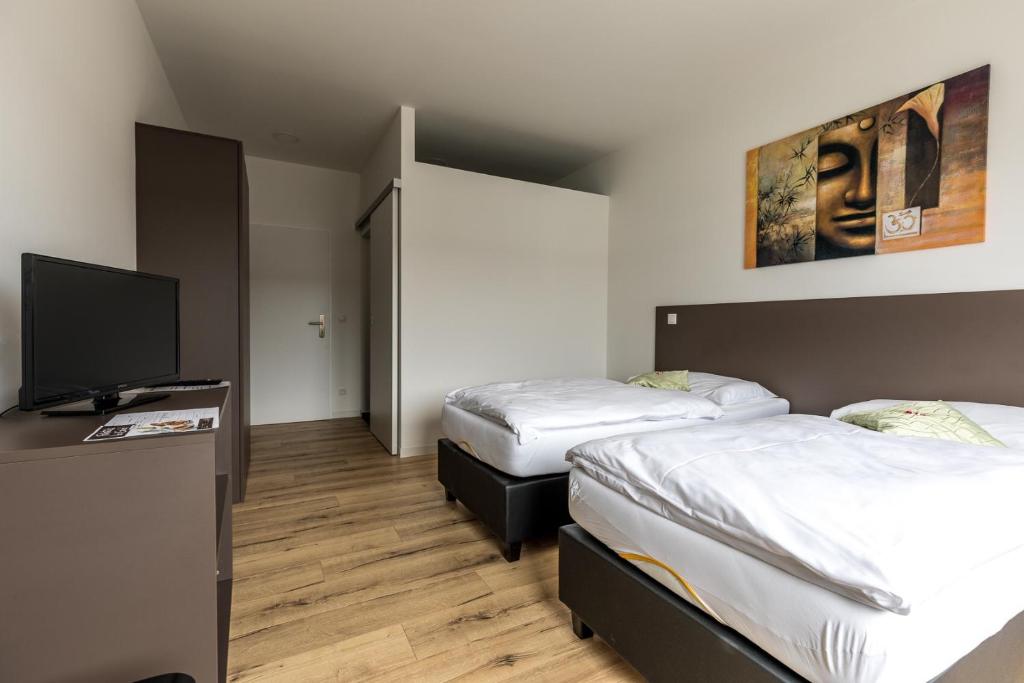 根瑟恩多夫Wein4tler-Motel的客房设有两张床和一台平面电视。