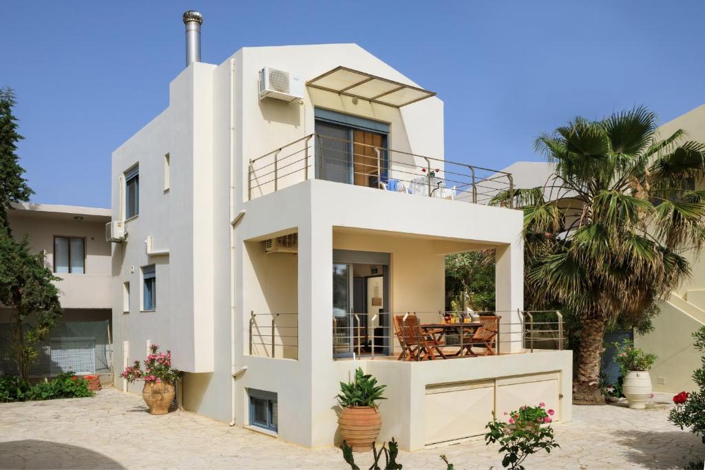 阿尔米里达Villa Giannis的带阳台和棕榈树的白色房屋