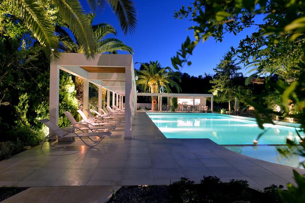 达西亚TRYP by Wyndham Corfu Dassia的一座房子旁带躺椅的游泳池