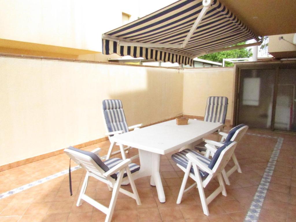 普拉加德阿罗Saromar I Apartament amb gran terrassa, per 6 persones a 5 minuts de la Platja Gran的庭院里的白色桌椅