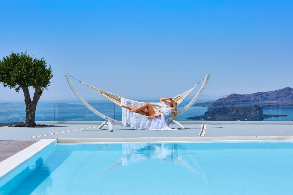 梅加洛克里温泉奢华别墅和Spa的坐在游泳池旁的吊床上的女人