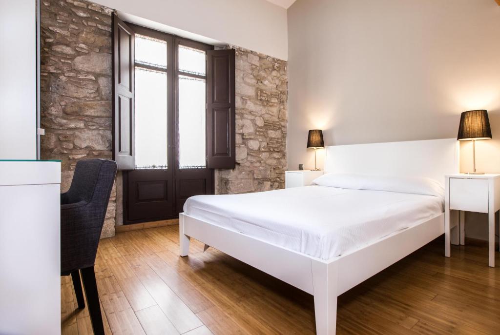 赫罗纳Girona Housing Ginesta 9的卧室配有白色的床和窗户。