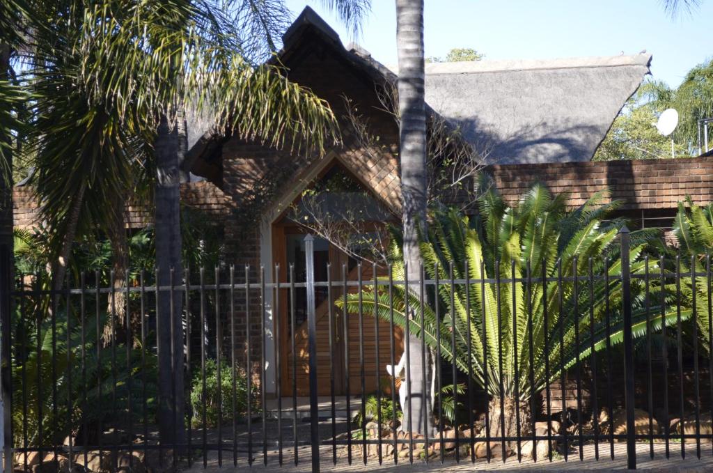 波罗瓜尼Birrea Guest house的棕榈树屋前的围栏
