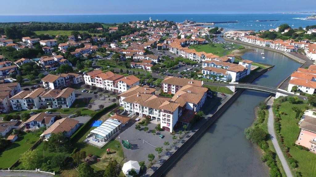 乌瑞基尼VVF Urrugne Saint-Jean-de-Luz Côte Basque的享有城镇的空中景致,设有房屋和河流