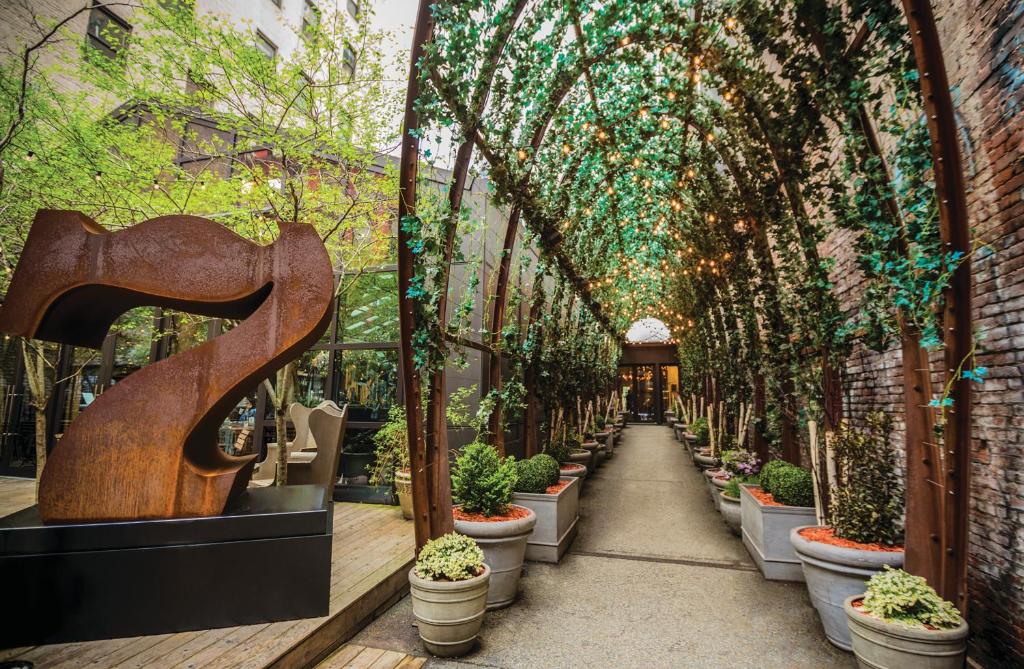 纽约野茂苏荷酒店的种满盆栽植物和树木的温室