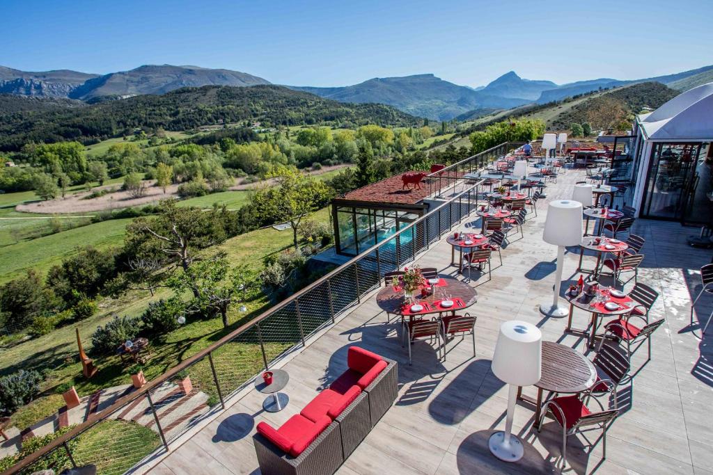 韦尔东河畔拉帕吕Hotel & Spa des Gorges du Verdon的户外庭院设有桌椅和山脉
