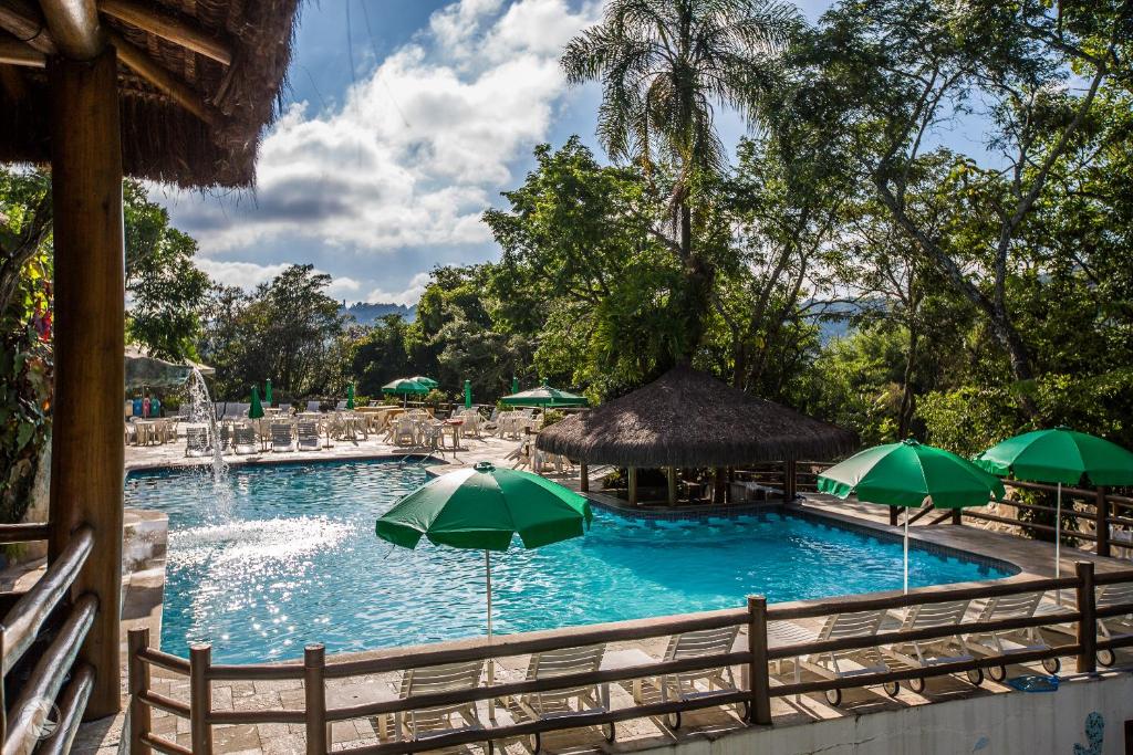 迈里波朗切罗德玛托度假村的一个带绿伞和椅子的大型游泳池