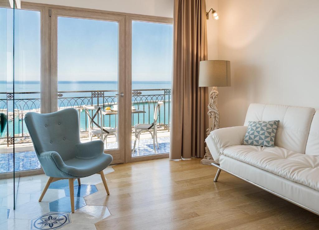 夏卡Domus Maris Relais Boutique Hotel的带沙发的客厅,享有海景