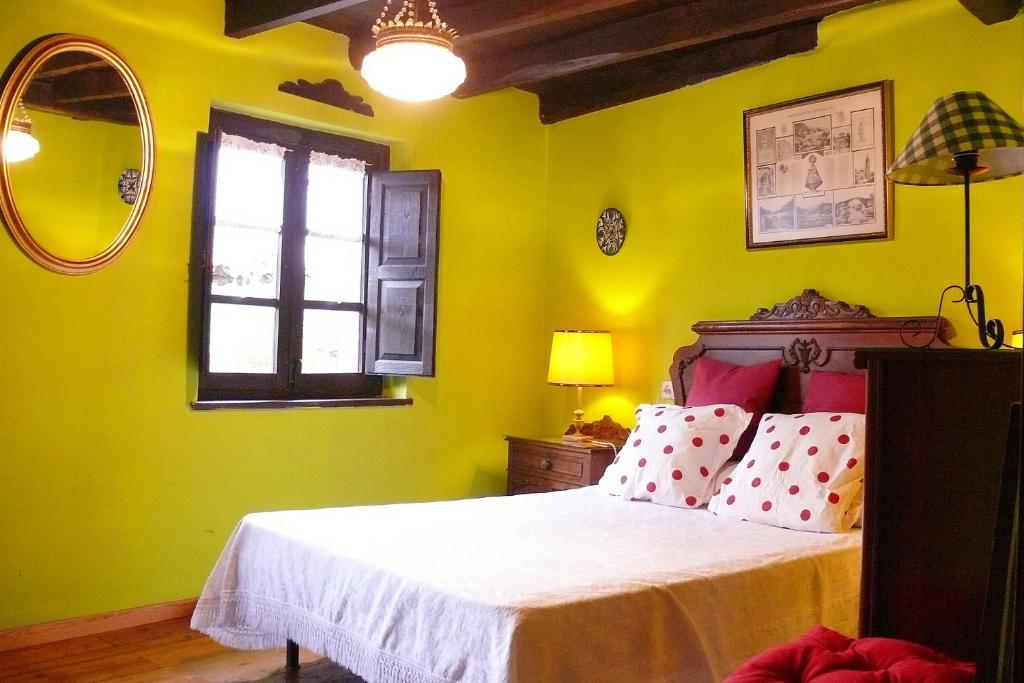 CelorioLa Casina de Celorio的一间卧室设有一张黄色墙壁和窗户的床
