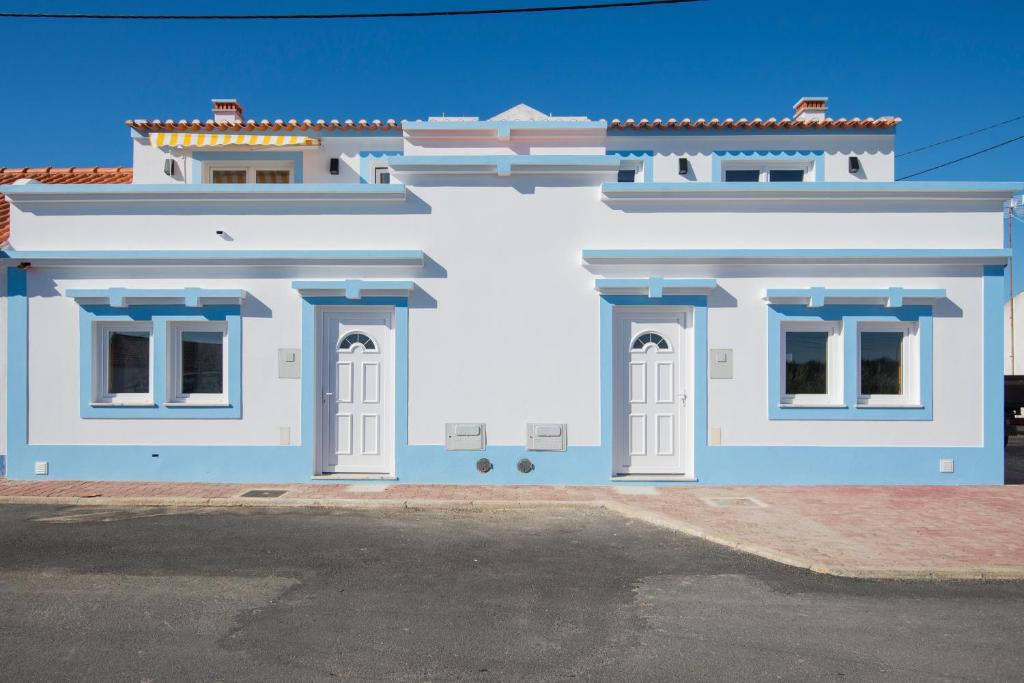 CavaleiroCavaleiro Rota Costa Alentejana的白色的建筑,在街上有蓝色的饰物