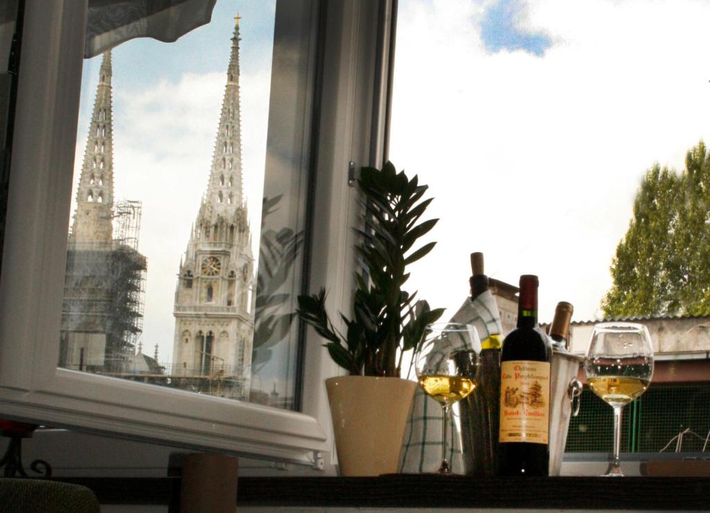 萨格勒布Apartment Classic Deco的窗户,带两杯葡萄酒,享有大本钟的景色