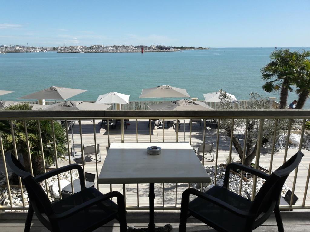 拉罗谢尔丽布立思酒店的海滩景阳台配有桌椅