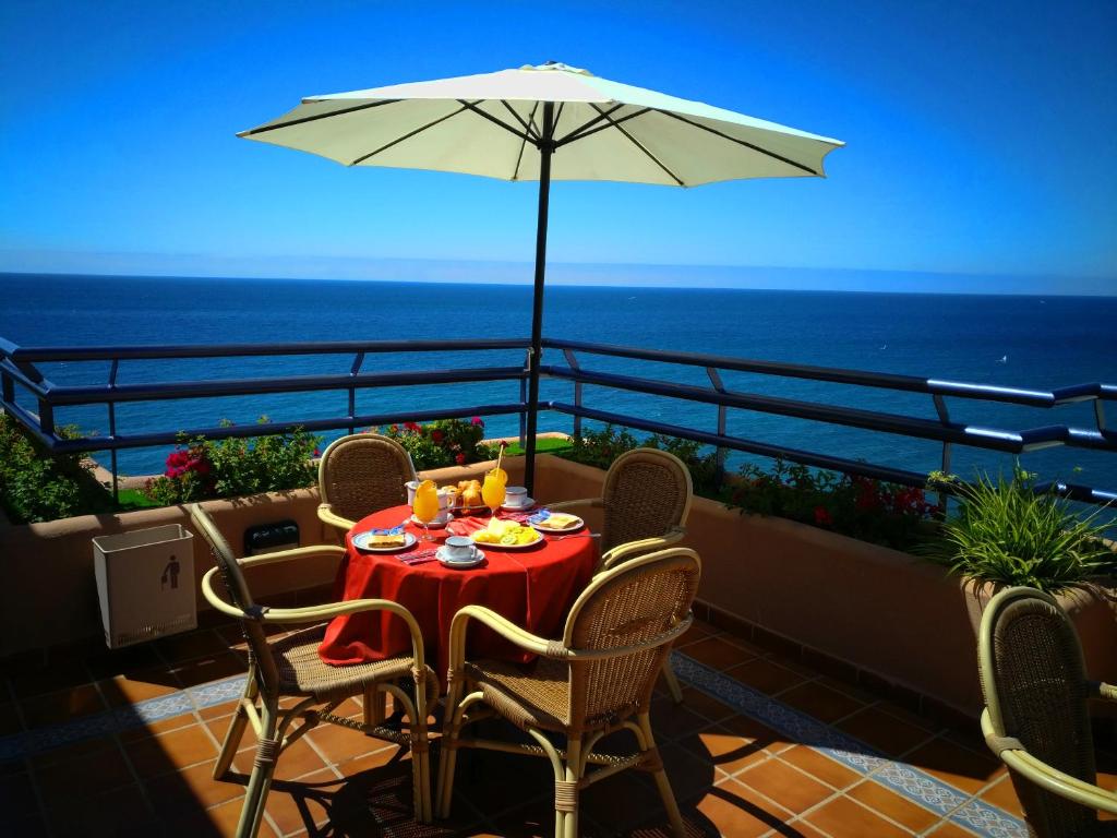 马贝拉Ona Princesa Playa的阳台上配有桌椅和遮阳伞