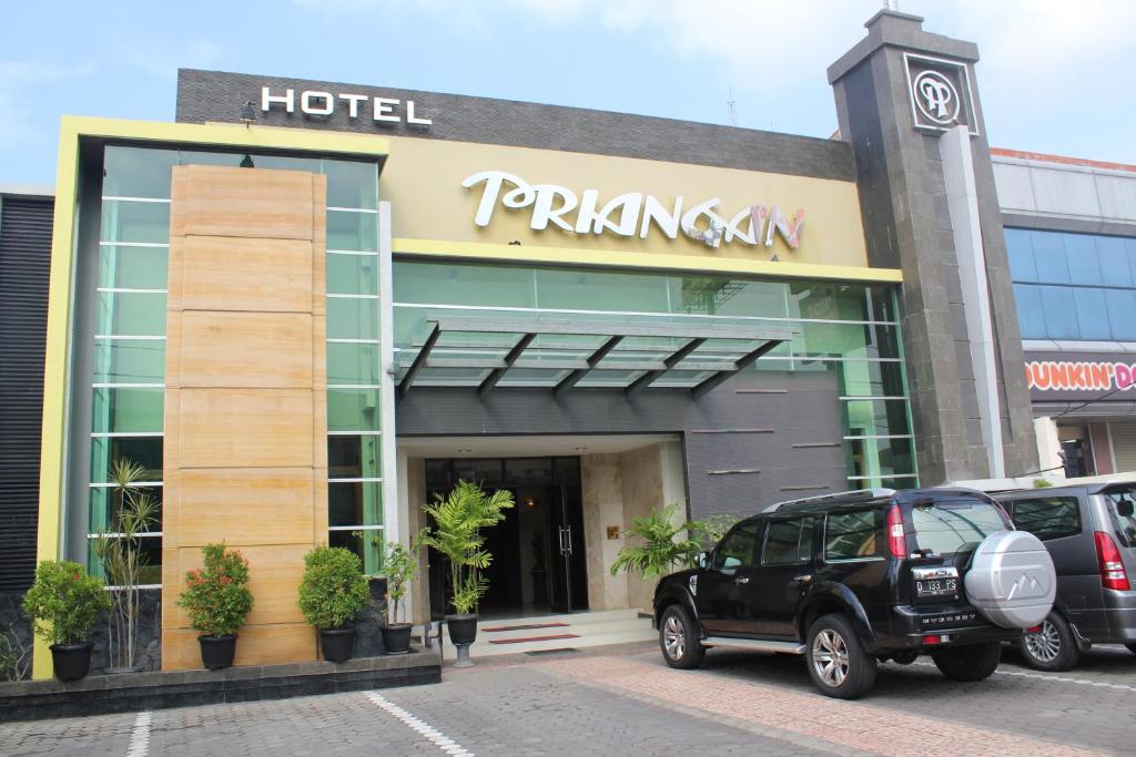 井里汶Hotel Priangan的门前有车辆停放的酒店