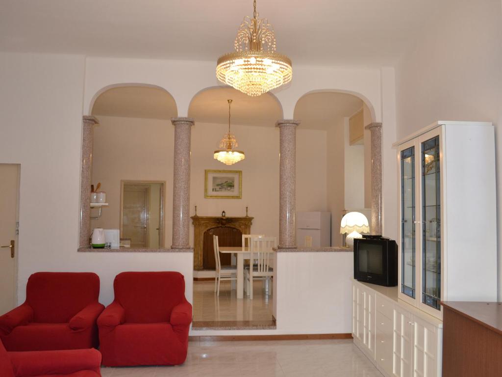 莱萨L'Antico Borgo的客厅配有2把红色椅子和电视