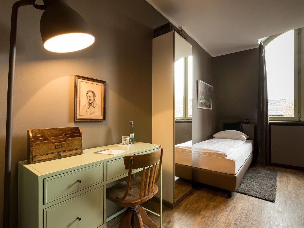 罗拉赫Hotel Heimathafen的一间卧室配有书桌和一张床