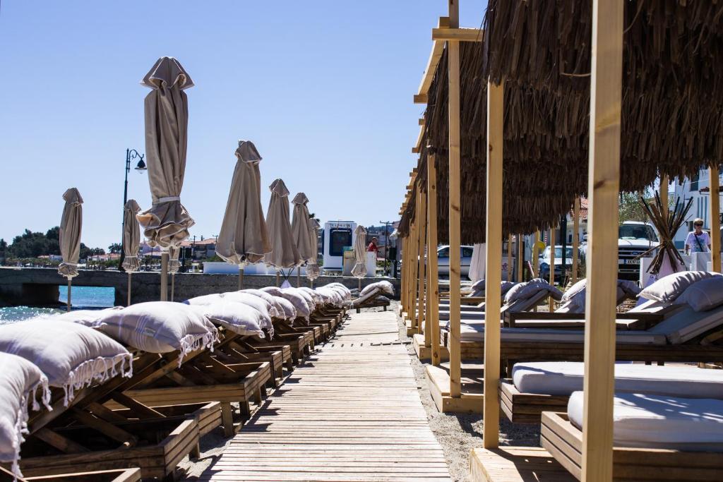 佩科霍里Adriana beach的码头上的一排雨伞和椅子