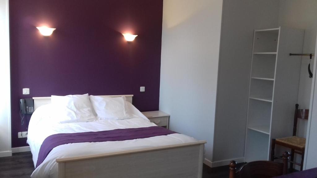 Le Theil-sur-Huisne鸣钟旅馆的卧室配有白色床和紫色墙壁