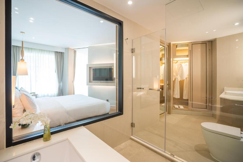 七岩华欣安凡尼臻选度假酒店的浴室设有床铺和玻璃淋浴间。
