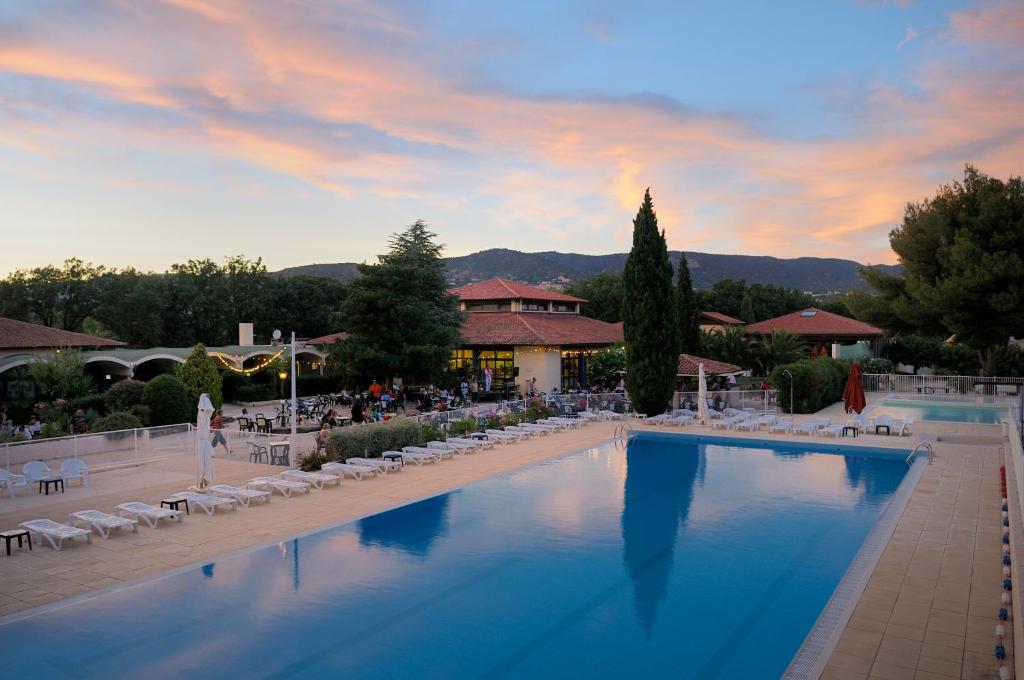 博尔马斯·莱斯·米默萨斯Village Vacances La Manne的一个带椅子的大型游泳池,一个度假村