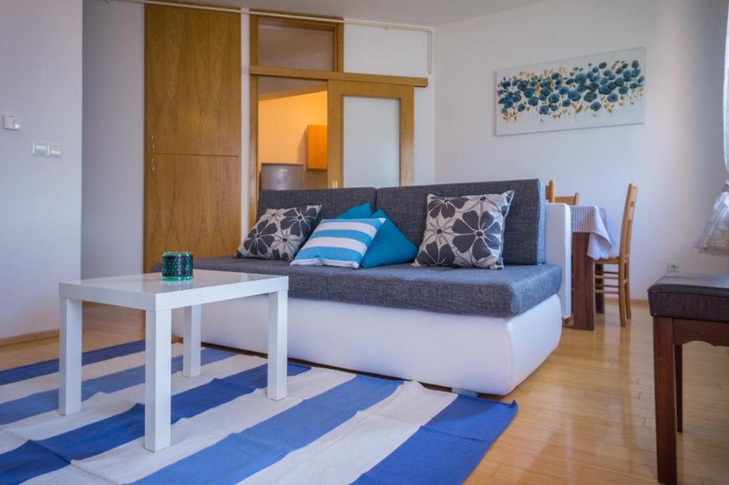萨格勒布Blue Lake Apartment的客厅配有沙发和桌子