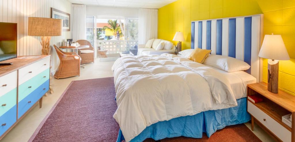 爱丽丝镇比米尼大型游戏俱乐部滨海度假酒店的一间卧室设有一张大床和黄色的墙壁