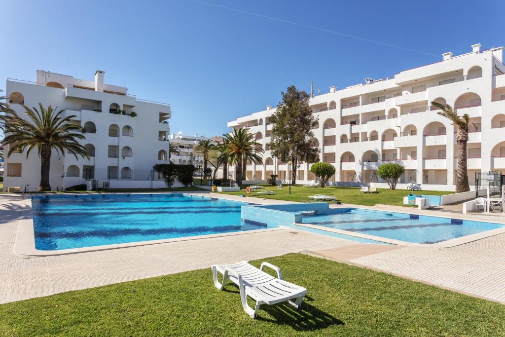 珀彻斯Andorinha 2 bedroom apart-close to the sea-Algarve的一座大建筑前的游泳池