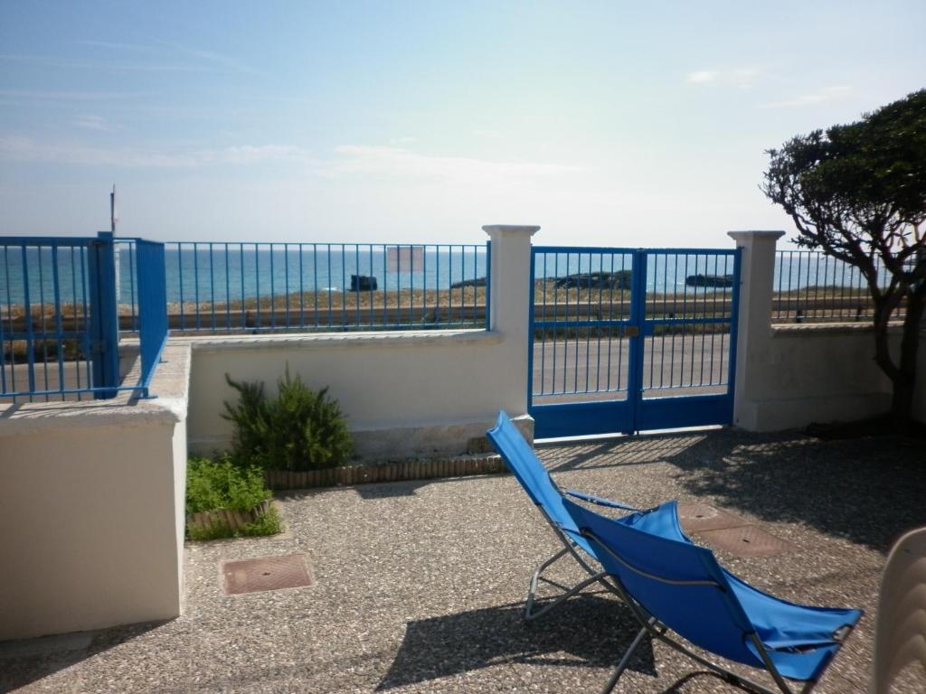 新福卡Villino sul mare的阳台的蓝色椅子,背景是大海