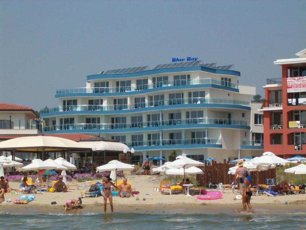 阳光海滩Blue Bay Hotel的海滩上与海滩上的人一起入住的酒店