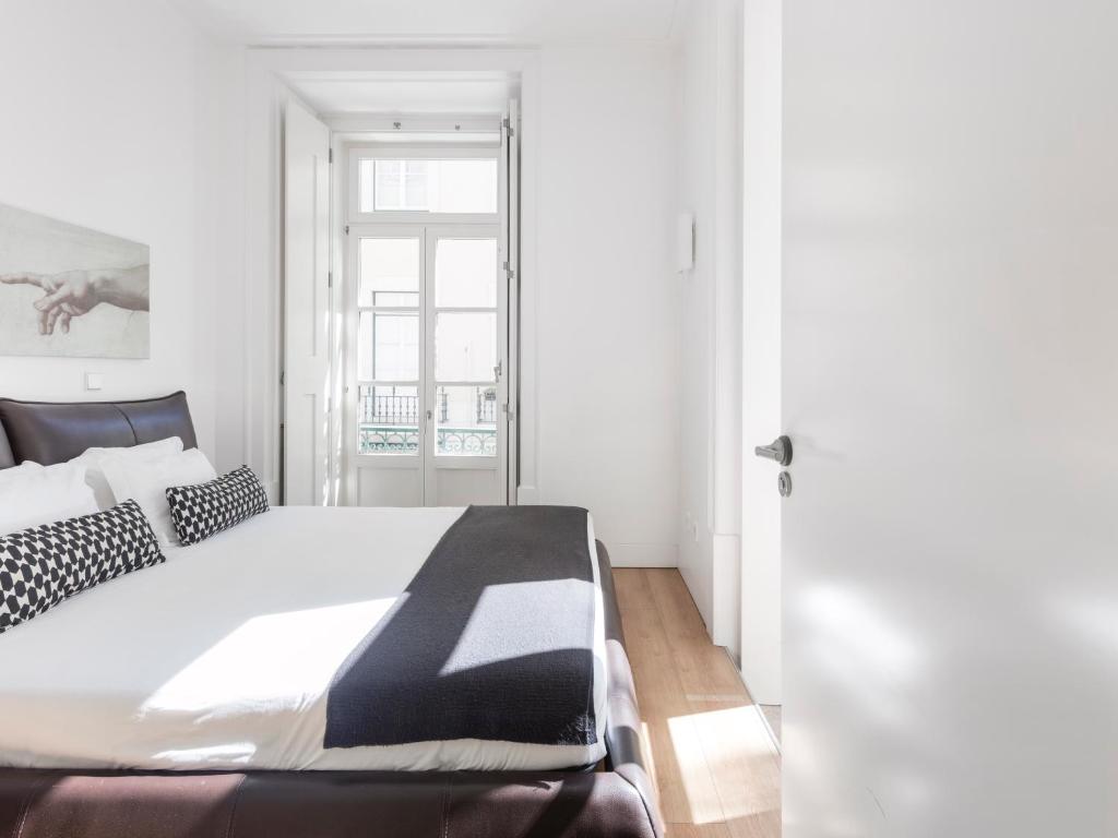 里斯本里斯本拜萨服务公寓式酒店的一间卧室配有一张大床,提供黑白枕头