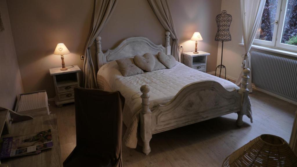 Schwenheim乐卡琳迪萨韦斯住宿加早餐酒店的一间卧室配有一张白色的床,桌子上配有两盏灯