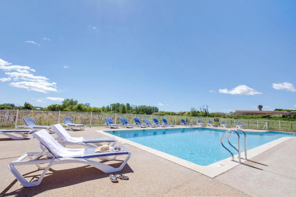 科隆比耶尔Vacancéole - Le Domaine d'Enserune的一个带躺椅的游泳池和一个游泳池