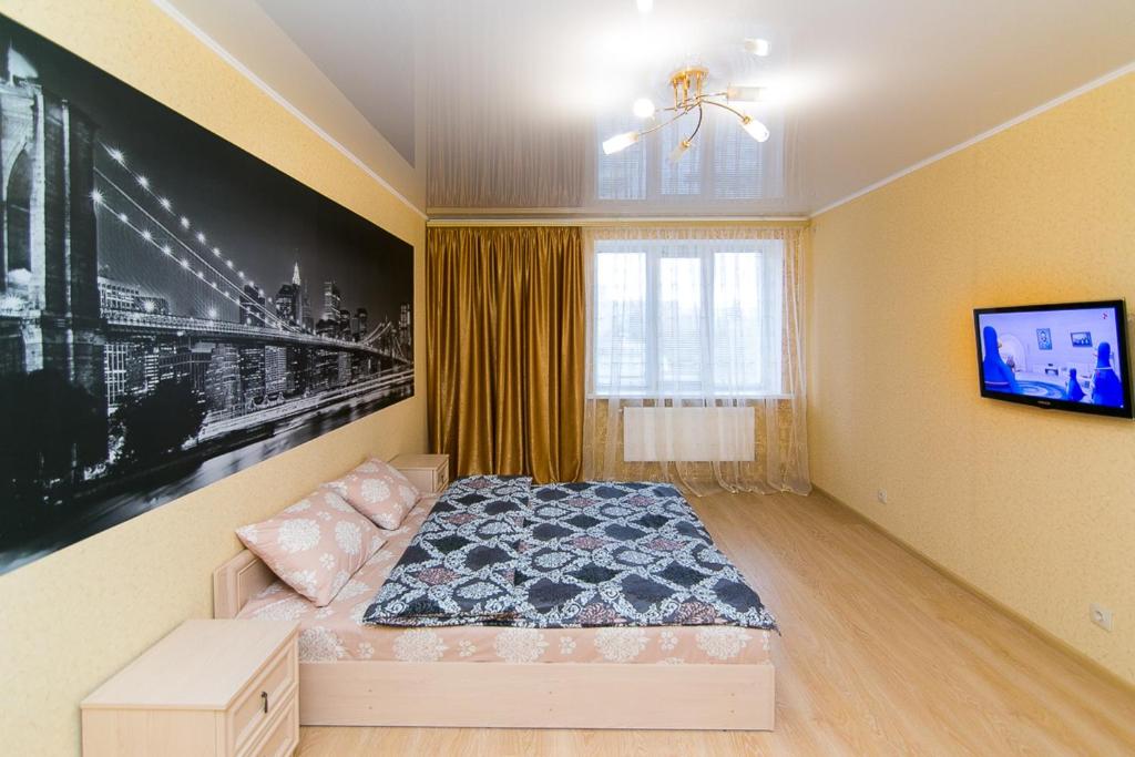 苏梅VIP Apartment on Novomestenskaya的一间卧室配有一张床,墙上配有电视