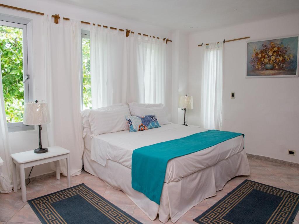 博卡奇卡Hotel Neptuno Refugio的一间白色卧室,配有床和2个窗户