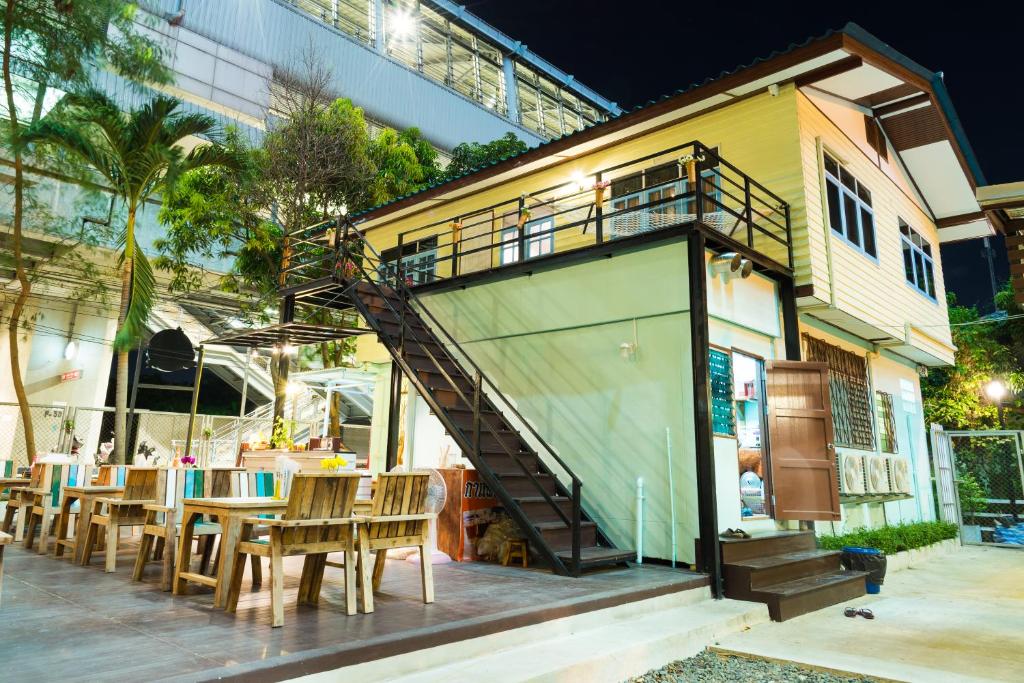 曼谷近素万那普机场NTY旅舍的一间有楼梯的餐厅,通往一座建筑
