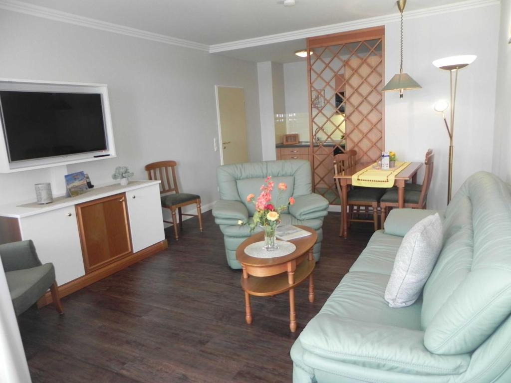 赛巴特班森Seehof 2_02的客厅配有沙发和带电视的桌子