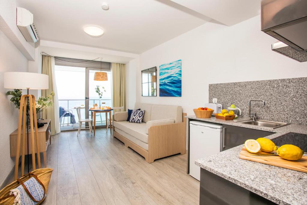 布拉内斯布拉内斯海滩皮埃尔假日公寓的厨房以及带沙发和桌子的客厅。