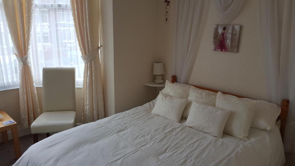 斯卡伯勒Sheridan的卧室配有白色床、椅子和窗户