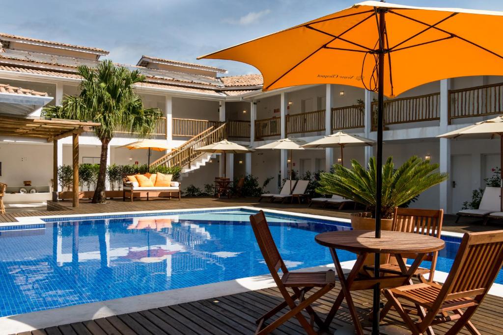 马利西亚斯Hotel Maui Maresias的游泳池旁带遮阳伞的桌子