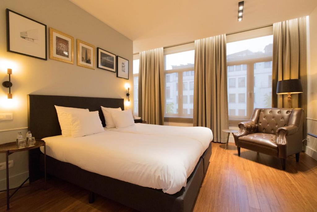 安特卫普埃米尔精品酒店的酒店客房带一张大床和一把椅子