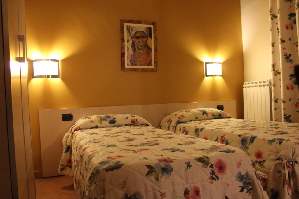 格拉维纳普利亚夸特洛丰滩住宿加早餐旅馆的酒店客房设有两张床,墙上挂着一张照片。