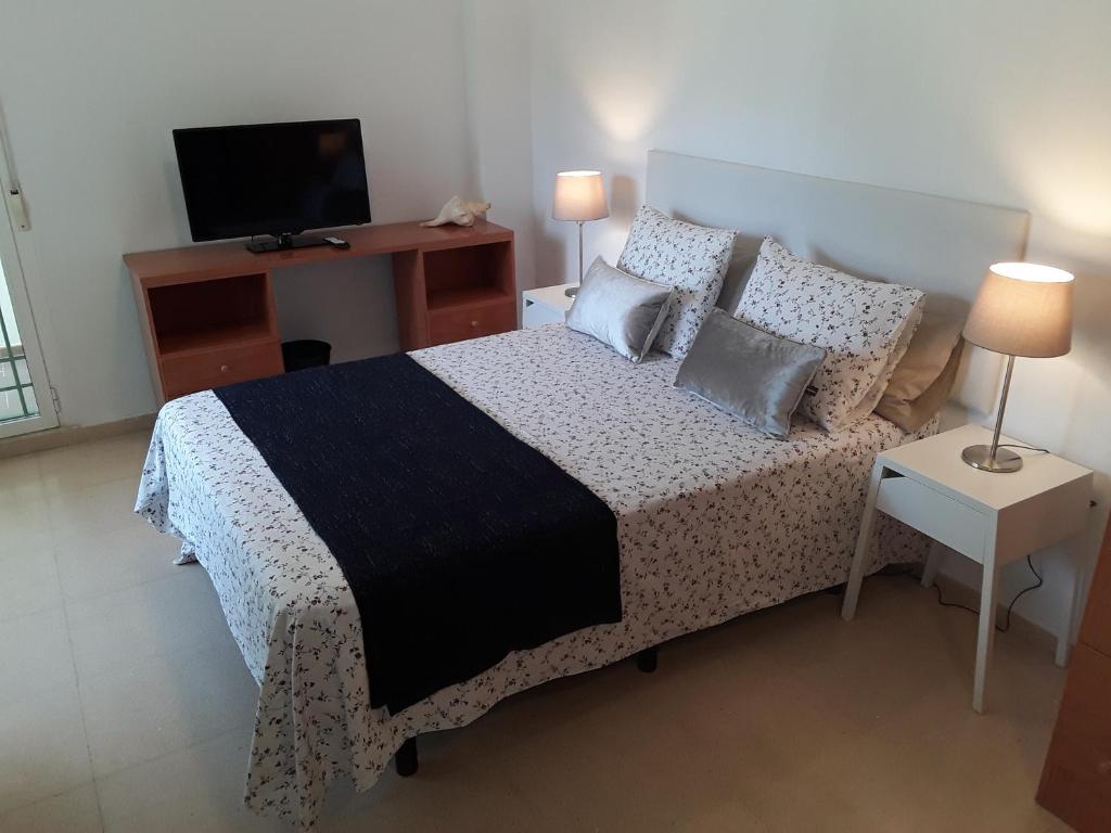 多列毛利诺斯Fan Flat Torremolinos的一间卧室配有一张带电视和桌子的床。